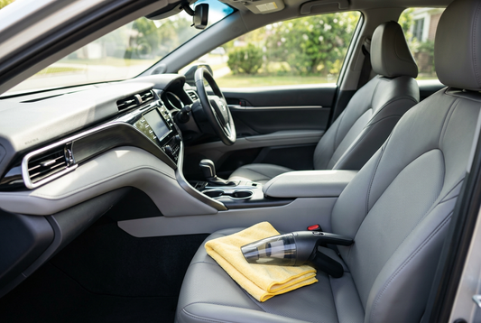 Intérieur de voiture propre et lumineux avec aspirateur à main et chiffon microfibre