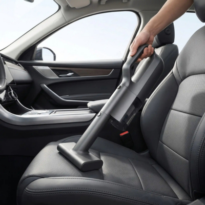 Aspirateur automobile sans fil nettoyant le siège d'une voiture