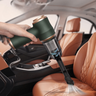 Aspirateur voiture silencieux vert foncé nettoyant la console d'une voiture