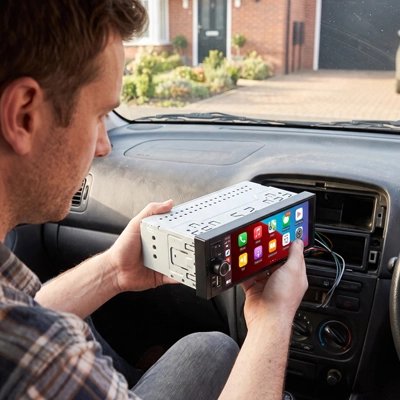 Homme installant l'autoradio CarPlay sans fil Serenity dans sa voiture