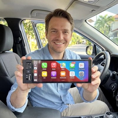 Conducteur souriant présentant l'autoradio CarPlay Serenity à écran large
